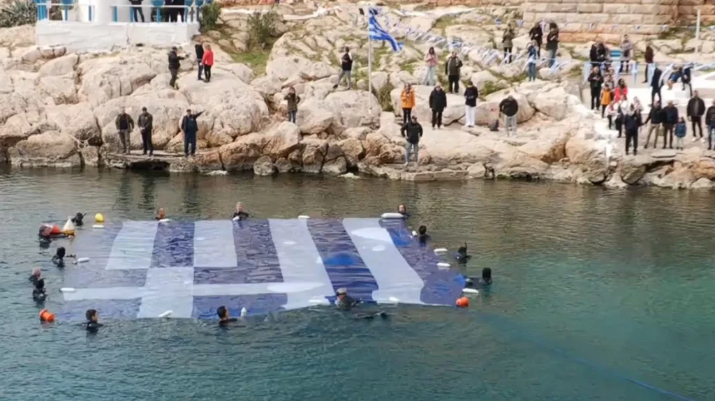 Τεράστια γαλανόλευκη σημαία 180 τ.μ. στην Πειραϊκή για την εθνική επέτειο της 25ης Μαρτίου, δείτε βίντεο Τεράστια γαλανόλευκη σημαία 180 τ.μ. στην Πειραϊκή για την εθνική επέτειο της 25ης Μαρτίου, δείτε βίντεο